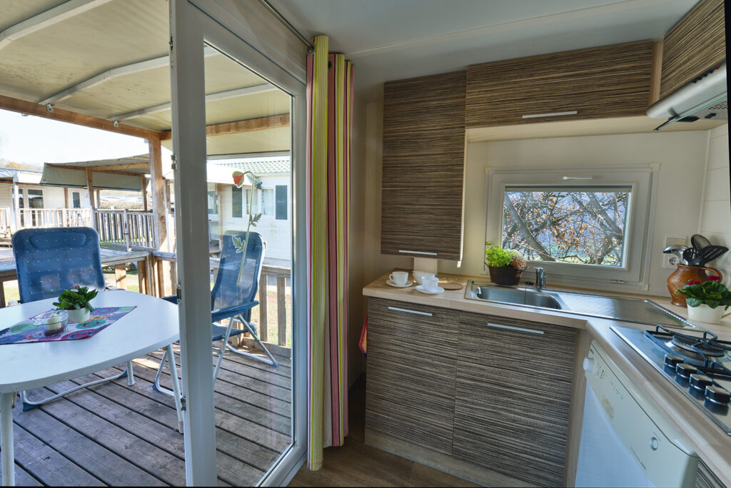 Fully equipped kitchen in the chalet with stove, refrigerator, and tableware.